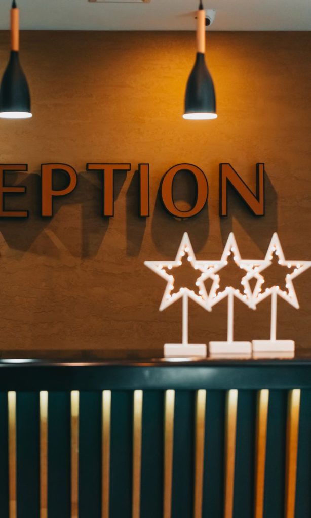 Modern hotel reception area with illuminated star decorations and warm lighting.